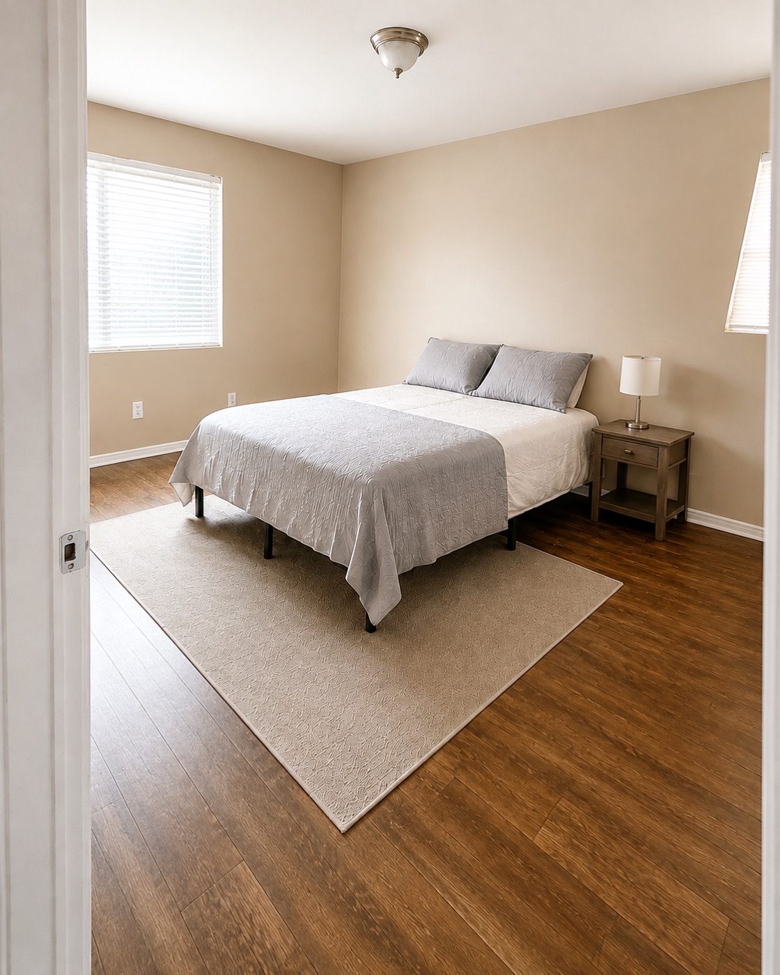 Bright bedroom with wood-look flooring and closet