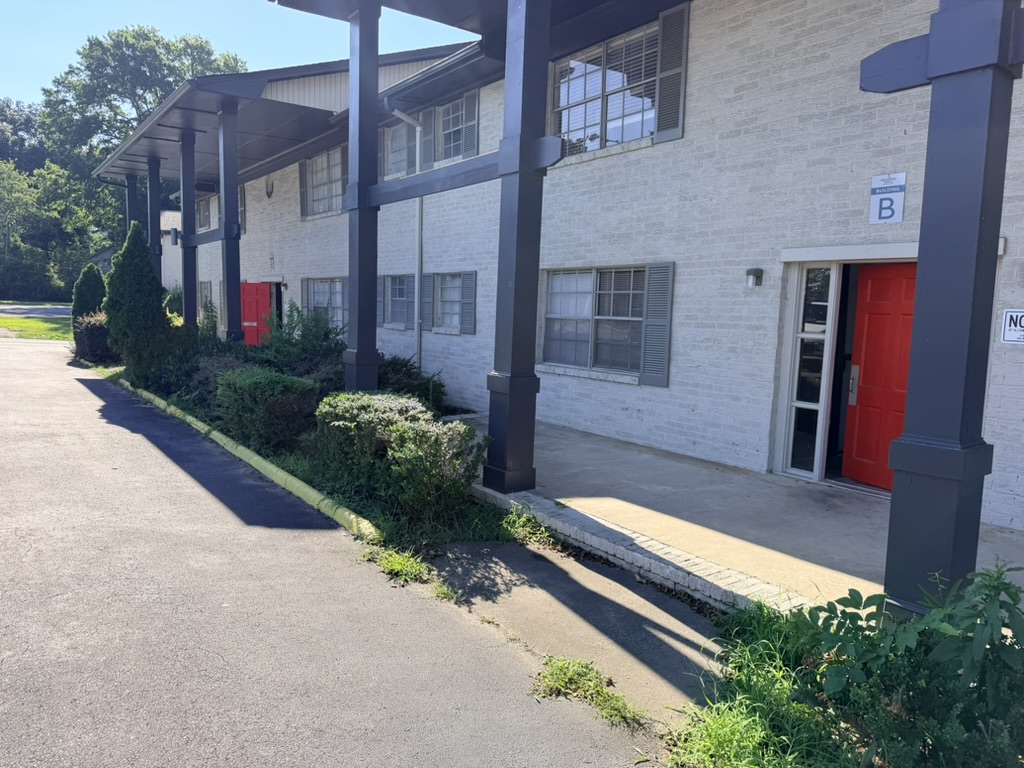 Angled view along a shaded apartment walkway